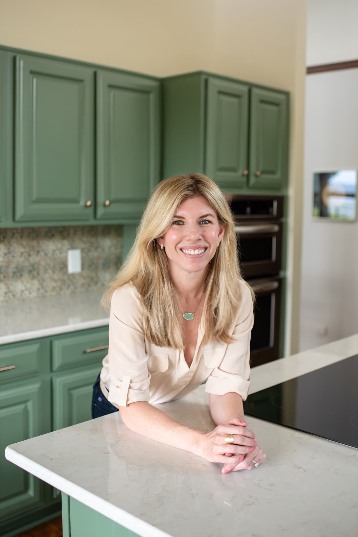 Goldie Barrett, leaning on a kitchen island and smiling